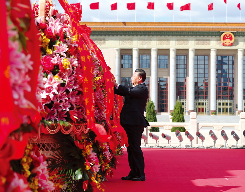 2018年9月30日上午，党和国家领导人习近平、李克强、栗战书、汪洋、王沪宁、赵乐际、韩正、王岐山等来到北京天安门广场，出席烈士纪念日向人民英雄敬献花篮仪式。这是习近平整理花篮上的缎带。 新华社记者 谢环驰/摄